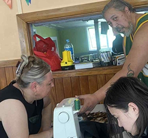 Whānau creating a korowai at a Peakman wānanga